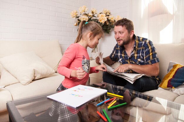 Girl looking at her father's newspaper