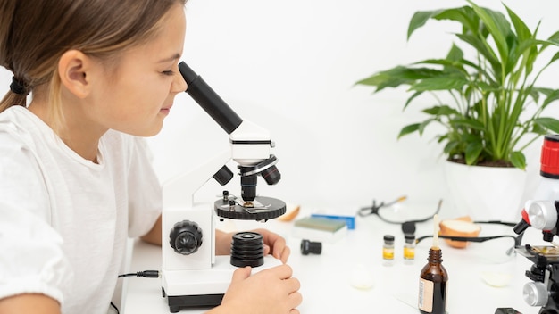 Free Photo girl looking into microscope