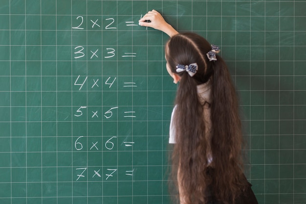 Free photo girl making calculations on blackboard