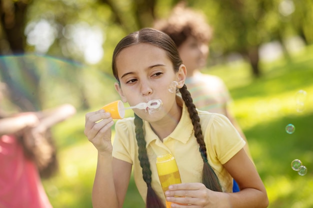 Girl making soap bubbles in park