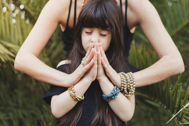 Girl meditating with mother