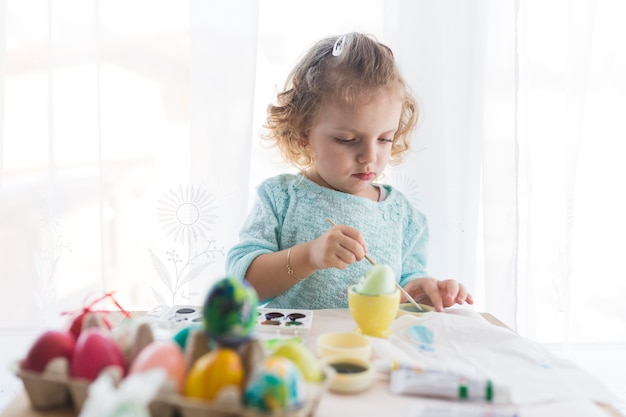 Girl mixing paint for egg