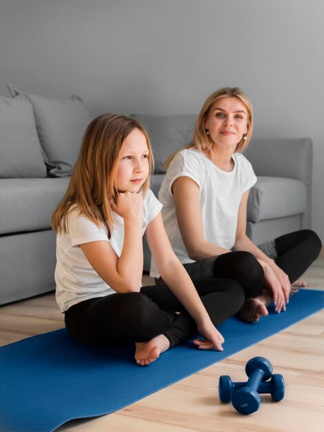 Girl and mom sitting on mat