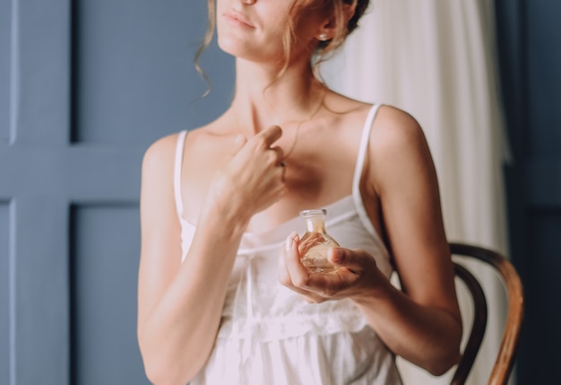 Free photo girl in the morning uses a perfume around her neck