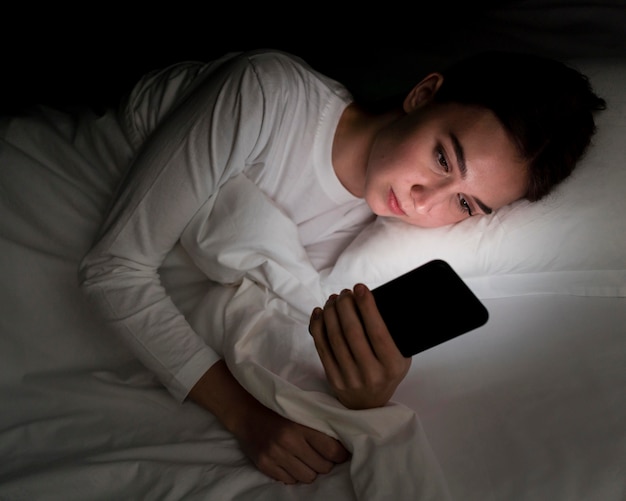 Girl at night in bed with phone