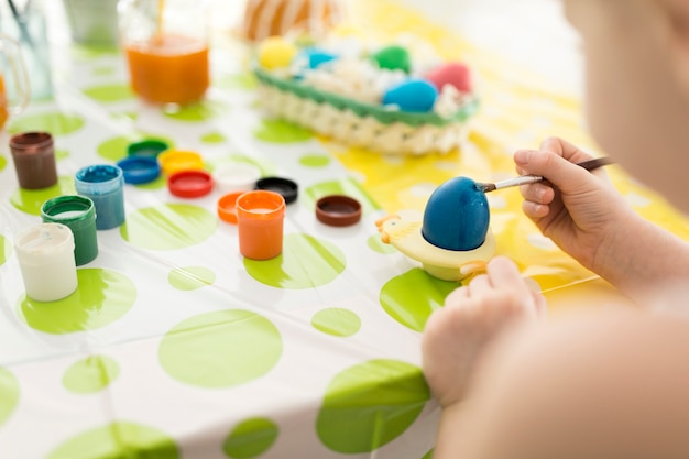 Free photo girl painting easter egg with blue