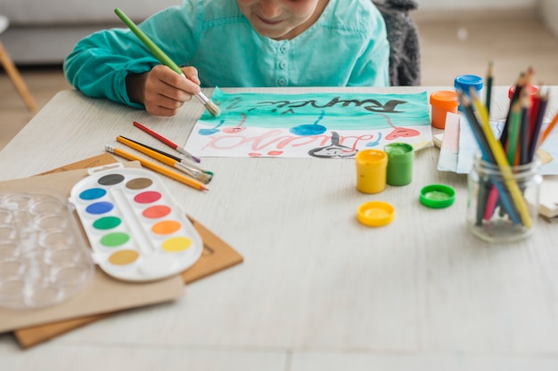 Girl painting with watercolor at home