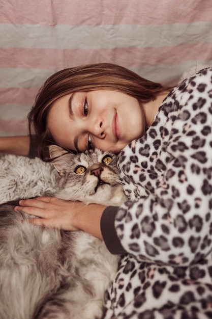 Free Photo girl in pajamas and cat in the bed