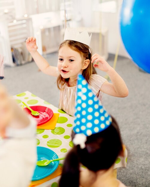 Girl in paper crown showing grimaces 