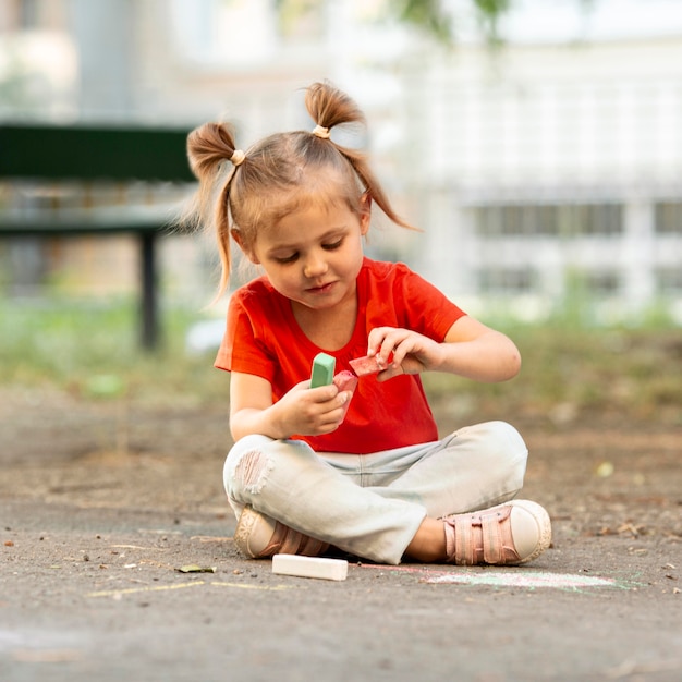 Free photo girl in park drawing with chalk