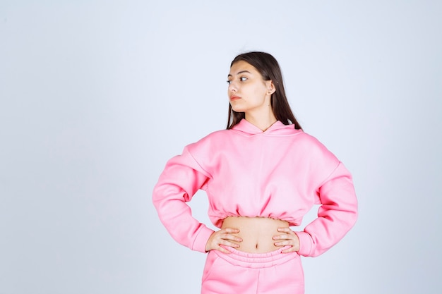 Free photo girl in pink pajamas giving dissatisfied and neutral poses