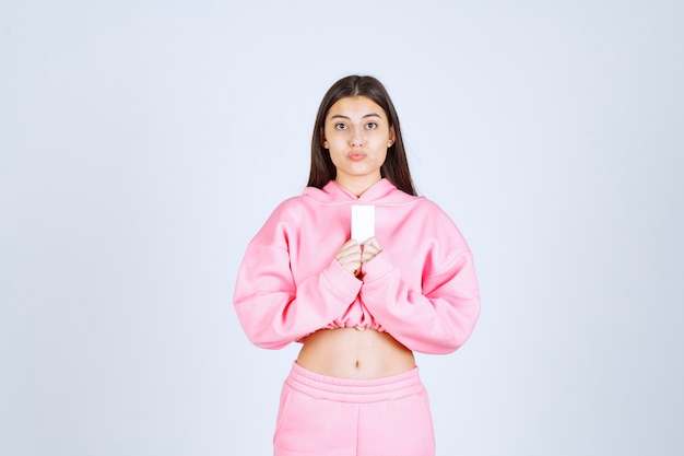 Girl in pink pajamas holding a business card and introducing herself to her business partners. 