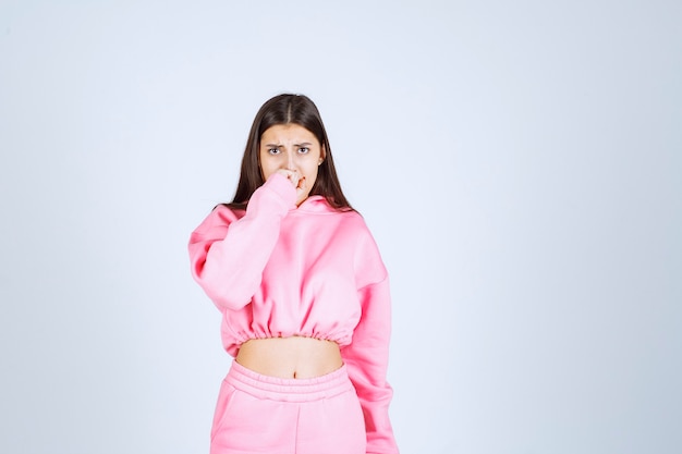 Girl in pink pajamas looks shocked and terrified