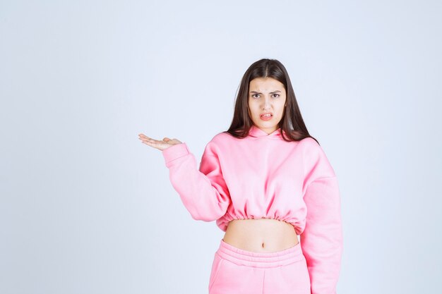 Girl in pink pajamas making very agressive and angry face