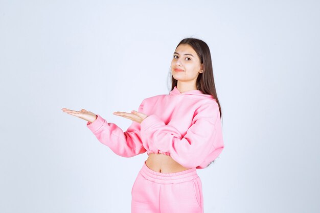 Girl in pink pajamas pointing at something on the left