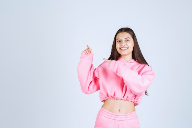 Girl in pink pajamas pointing up