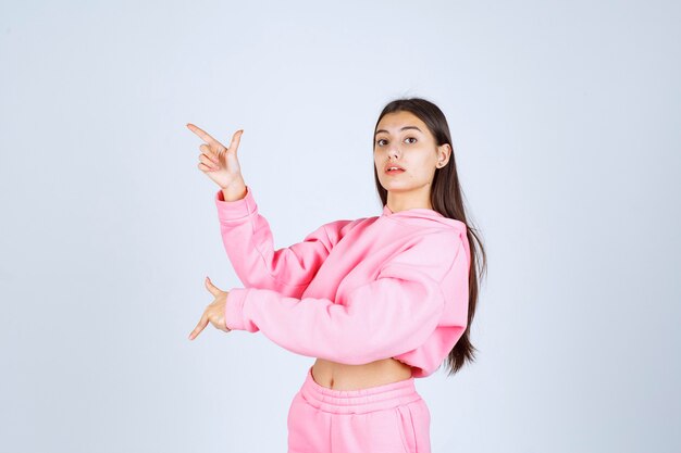 Girl in pink pajamas pointing up