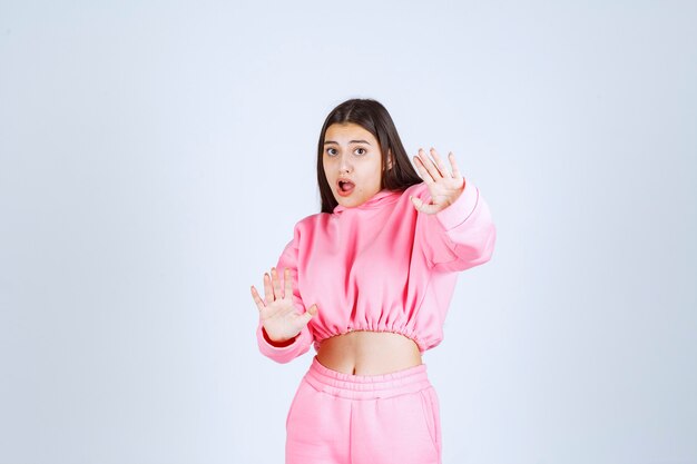 Girl in pink pajamas stopping something