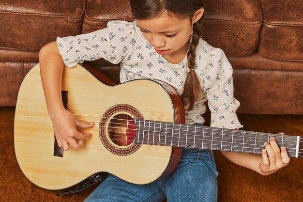 Girl playing guitar at home