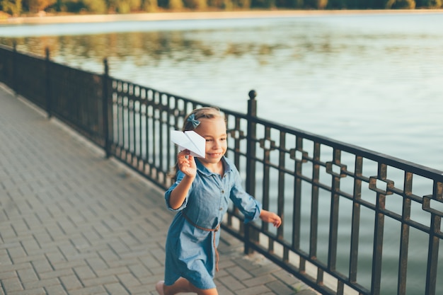 Free Photo girl playing, running with toy paper airplane