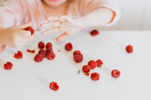 Free photo girl playing with raspberry