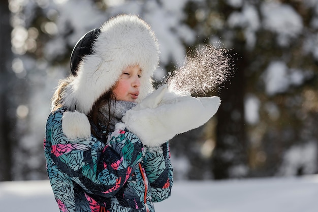 Girl playing with snow outdoors medium shot