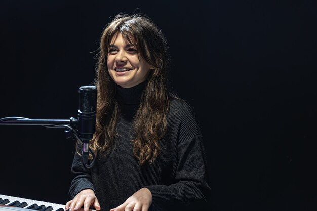 The girl plays the piano in the recording studio professional sound recording