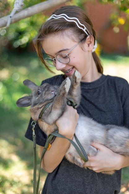 Free Photo a girl plays with a domestic rabbit on the street pet concept