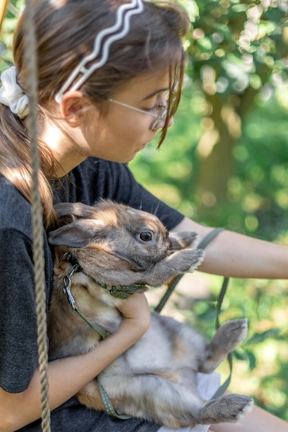 Free Photo a girl plays with a domestic rabbit on the street pet concept