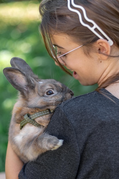 Free Photo a girl plays with a domestic rabbit on the street pet concept