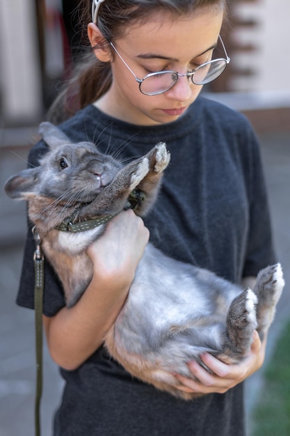 Free Photo a girl plays with a domestic rabbit on the street pet concept