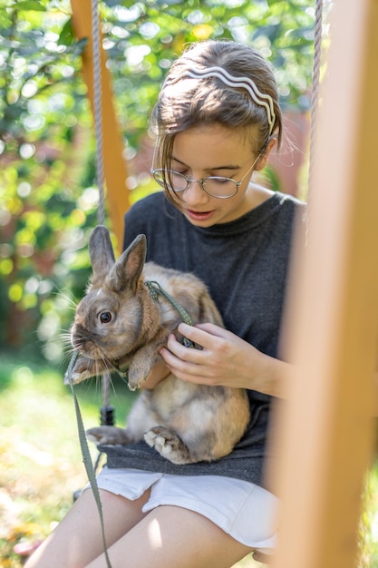 Free Photo a girl plays with a domestic rabbit on the street pet concept