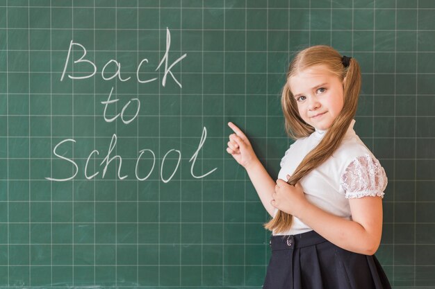 Girl pointing at back to school lettering on backboard