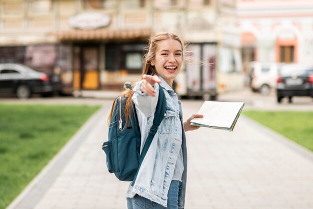 Girl pointing with her finger and holding a map