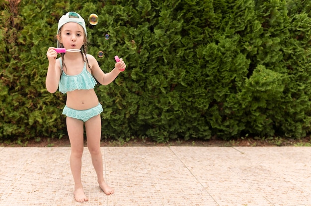 Girl at pool making soap bubbles