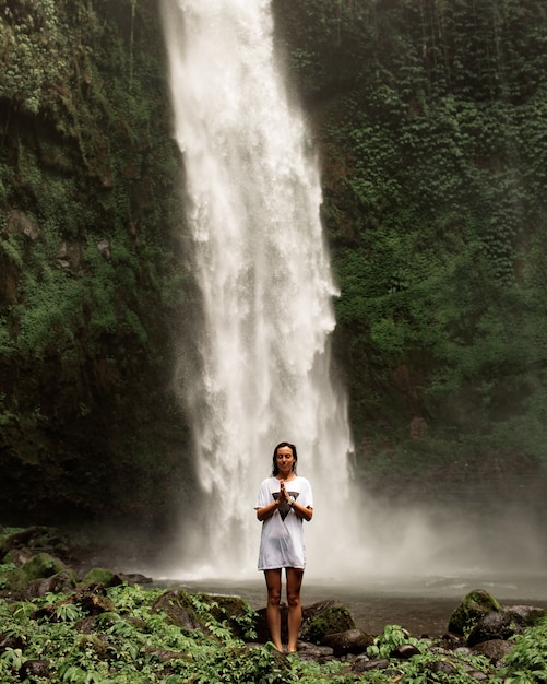 Free Photo girl posing against the backdrop of a waterfall