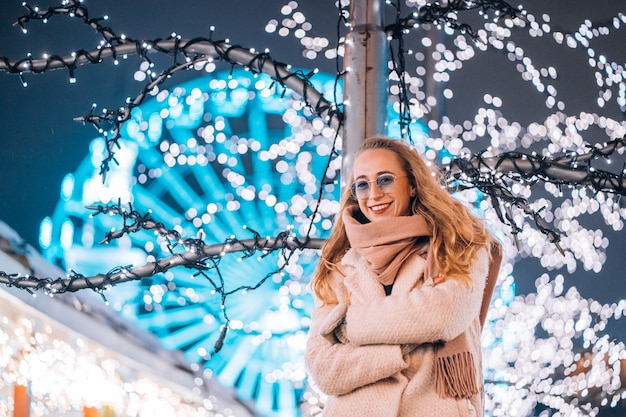 Free photo girl posing against the background of decorated trees