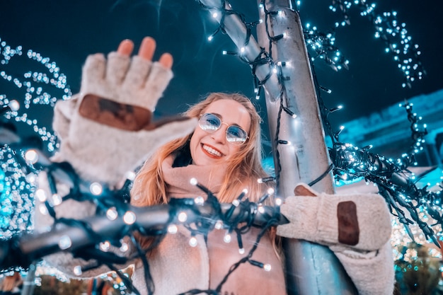 Free photo girl posing against the background of decorated trees