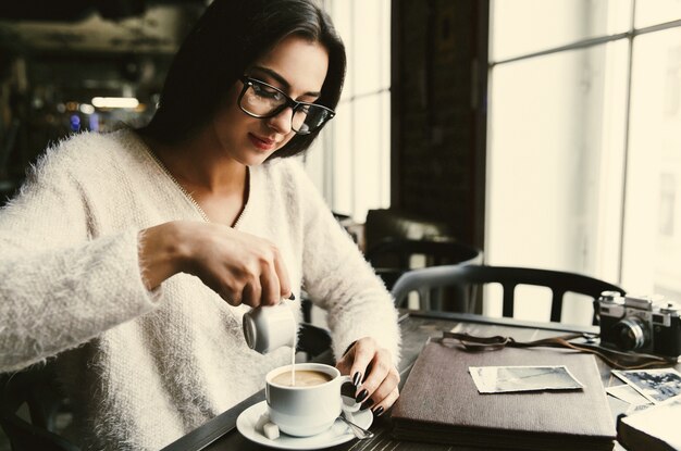 Free Photo girl pours milk in a cup of coffee