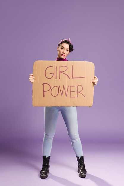 Girl power lettering on cardboard and woman standing