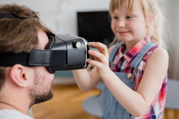 Girl putting VR headset on father