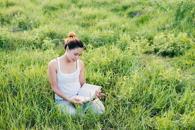 Girl reading a book on the graas