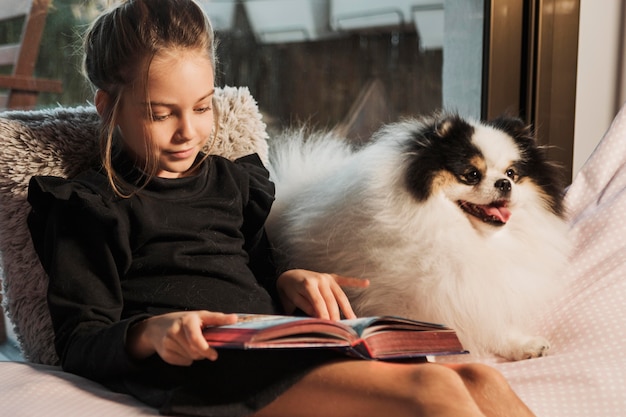 Girl reading and dog listening