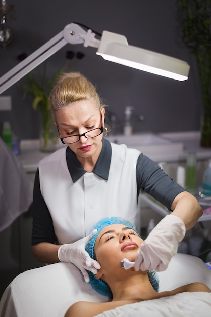 Free photo girl receiving facial treatment in a beauty salon