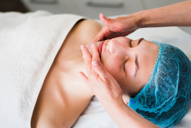 Free photo girl receiving facial treatment in a beauty salon