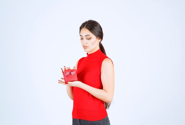 Girl in red shirt demonstrating her red gift box.