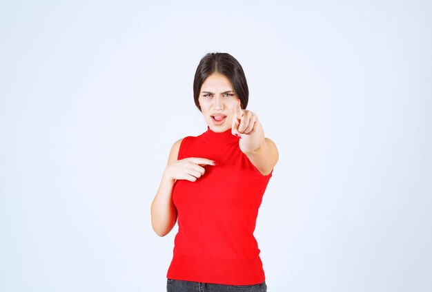 Girl in red shirt looks sad and disappointed.