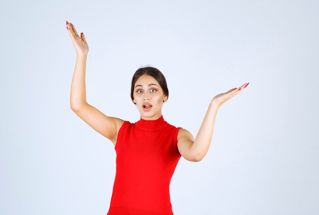 Girl in red shirt pointing at both sides.