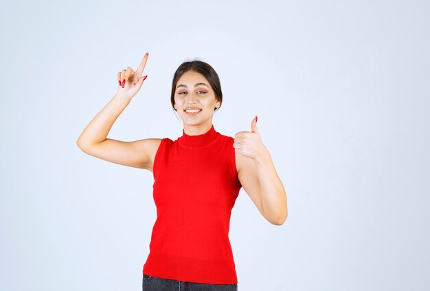 Girl in red shirt showing positive hand sign.