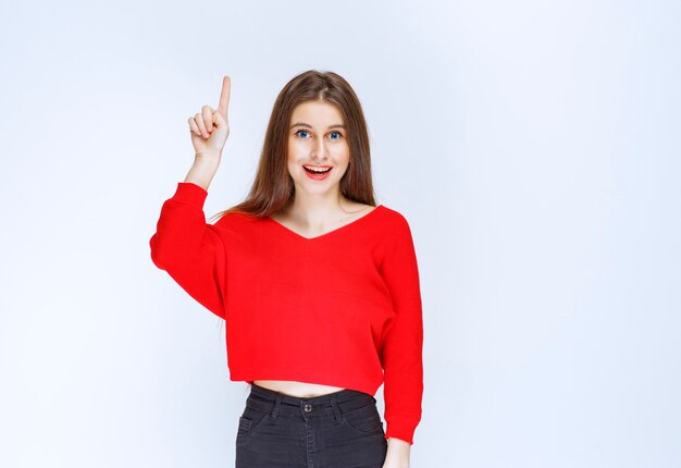 Girl in red shirt showing something upside. 